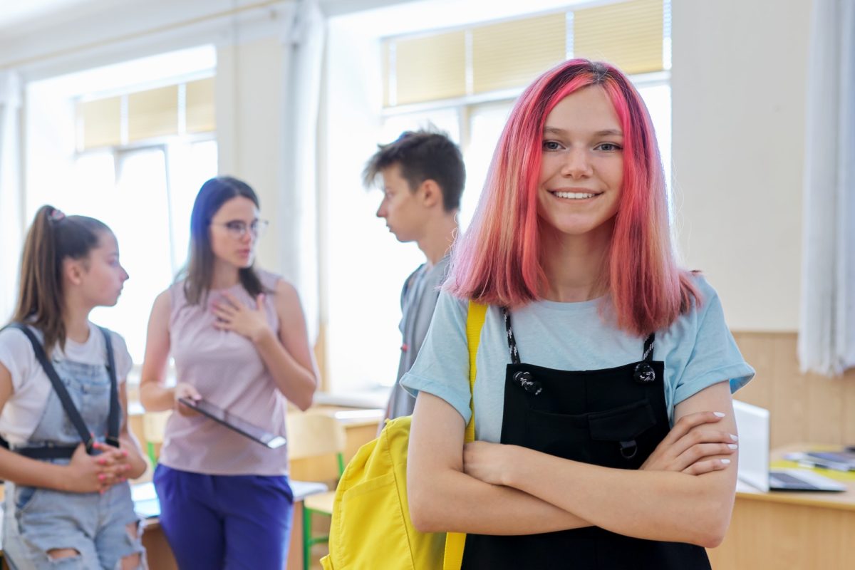 Portrait of smiling teenage girl in class on break