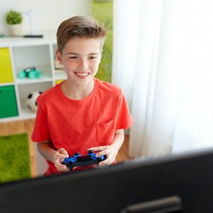 boy with gamepad playing video game on computer